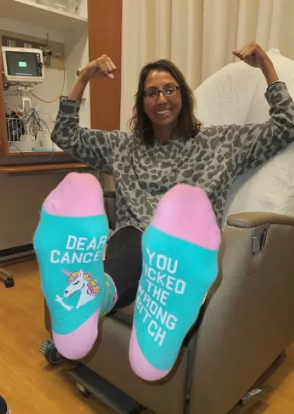 Joni's very cool cancer socks, reading "Dear Cancer, You Picked the Wrong Bitch."